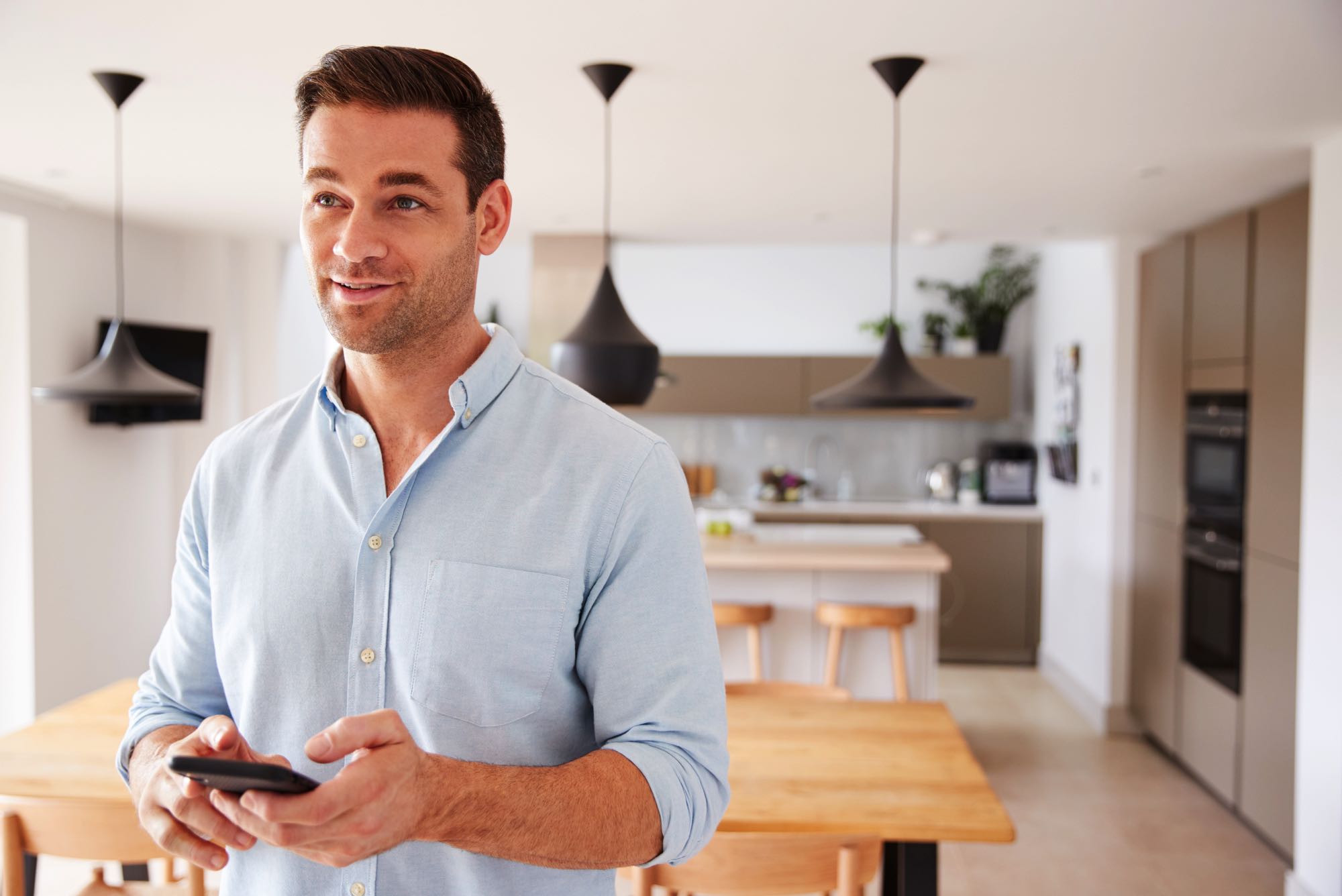 man-using-app-on-smart-phone-to-control-central-he-8ECPAY7